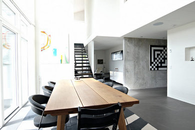 Diseño de comedor minimalista grande sin chimenea con paredes blancas y suelo negro