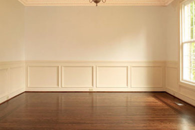 Modelo de comedor cerrado con paredes beige y suelo de madera en tonos medios