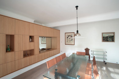 Photo of a contemporary dining room in London with white walls and light hardwood flooring.