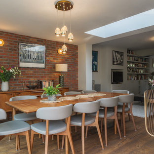 Photo of a medium sized contemporary open plan dining room in London with brown floors, white walls and dark hardwood flooring.