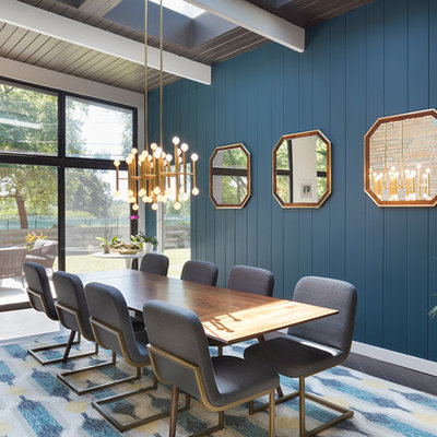 Example of a mid-century modern dining room design in Kansas City with blue walls and no fireplace
