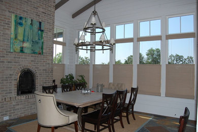 Medium sized contemporary kitchen/dining room in Atlanta with white walls, ceramic flooring, a standard fireplace, a brick fireplace surround and multi-coloured floors.