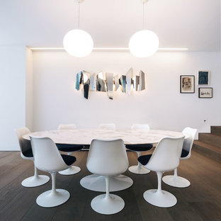 Contemporary dining room in London with white walls, dark hardwood flooring and brown floors.