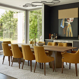 Photo of a contemporary open plan dining room in London with white walls, medium hardwood flooring, no fireplace and brown floors.