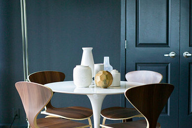 Inspiration for a 1960s medium tone wood floor dining room remodel in Houston with black walls