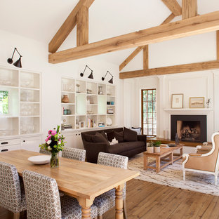 Foto di una grande sala da pranzo aperta verso il soggiorno country con pareti bianche e pavimento in legno massello medio