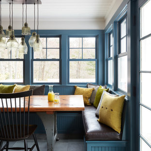Cette image montre une salle à manger ouverte sur la cuisine rustique de taille moyenne avec un mur blanc, un sol en ardoise et un sol gris.