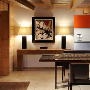 Aménagement d'une grand salle à manger ouverte sur le salon éclectique avec un mur beige et un sol beige.