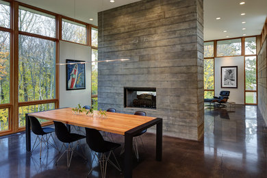 Inspiration for a mid-sized contemporary concrete floor and brown floor great room remodel in Milwaukee with a two-sided fireplace and white walls