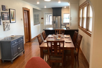 Example of a mid-sized medium tone wood floor and brown floor kitchen/dining room combo design in Other with white walls