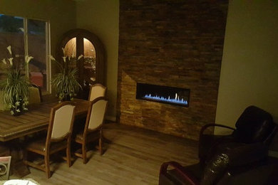 Small trendy enclosed dining room photo in Las Vegas with a stone fireplace