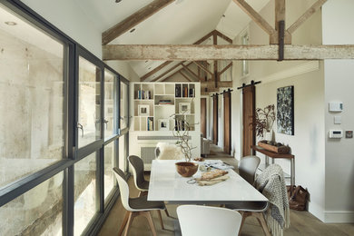 Enclosed dining room - industrial medium tone wood floor and brown floor enclosed dining room idea in Other with gray walls