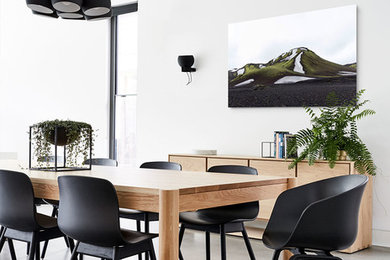 Cette image montre une salle à manger design fermée avec sol en béton ciré, un mur blanc et un sol gris.