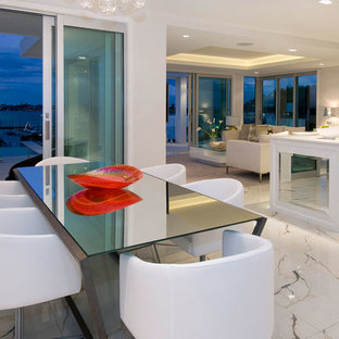 Immagine di una sala da pranzo aperta verso il soggiorno minimal con pavimento in marmo e pavimento bianco