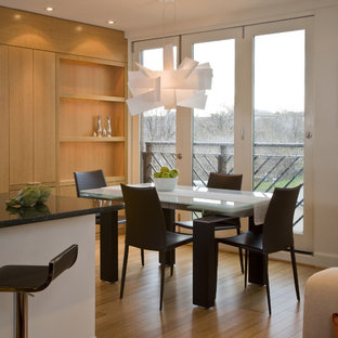 Esempio di una sala da pranzo aperta verso la cucina minimalista con pareti bianche e pavimento in legno massello medio