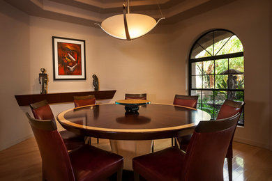 Immagine di una sala da pranzo contemporanea chiusa e di medie dimensioni con pareti marroni, pavimento in legno massello medio, nessun camino e pavimento marrone