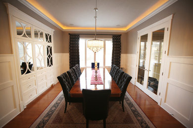 Example of a mid-sized classic medium tone wood floor enclosed dining room design in Edmonton with gray walls and no fireplace