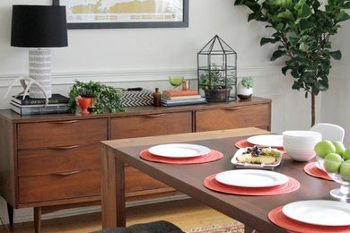 Aménagement d'une salle à manger ouverte sur la cuisine rétro de taille moyenne avec un mur blanc, un sol en bois brun et éclairage.