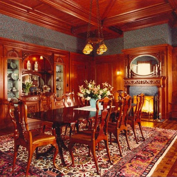 Formal dining room with wood panel walls and detailed wood celling