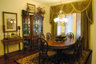 Imagen de comedor clásico de tamaño medio cerrado sin chimenea con paredes amarillas, suelo de madera oscura y suelo marrón