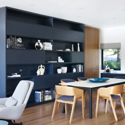 Example of a large trendy medium tone wood floor and brown floor great room design in Sydney with white walls and no fireplace