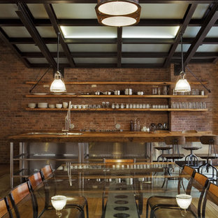 Idee per una sala da pranzo aperta verso la cucina industriale di medie dimensioni con pavimento in legno massello medio, pareti rosse e pavimento marrone