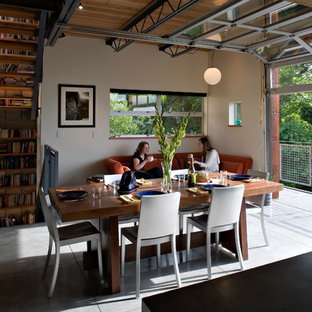 Esempio di una sala da pranzo aperta verso il soggiorno industriale di medie dimensioni con pavimento in cemento e pareti bianche