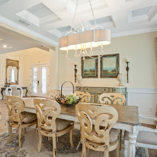 Idée de décoration pour une salle à manger avec un sol en bois clair, un plafond à caissons et boiseries.