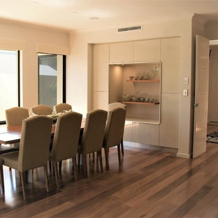 Aménagement d'une grand salle à manger ouverte sur le salon moderne avec un mur blanc, un sol en bois clair et un sol jaune.