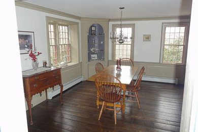 Example of a mid-sized classic dark wood floor and brown floor enclosed dining room design in Bridgeport with white walls and no fireplace