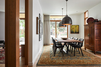 Foto di una sala da pranzo etnica chiusa e di medie dimensioni con pareti bianche, parquet chiaro, nessun camino e pavimento beige