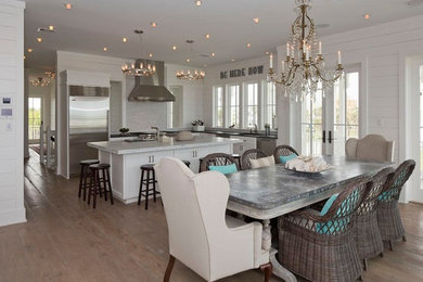 На фото: кухня-столовая в морском стиле с белыми стенами, паркетным полом среднего тона и коричневым полом с