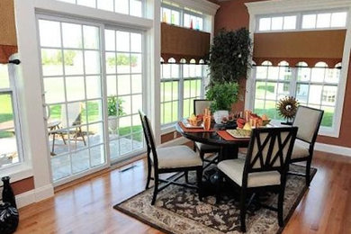 Inspiration for a mid-sized medium tone wood floor enclosed dining room remodel in Detroit with orange walls