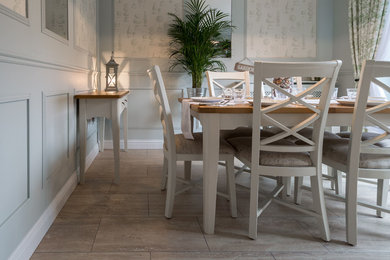 Idée de décoration pour une salle à manger design fermée et de taille moyenne avec un mur gris et un sol en travertin.