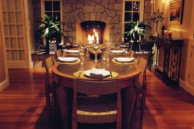 Foto de comedor tradicional de tamaño medio cerrado con paredes beige, suelo de madera en tonos medios, suelo marrón, todas las chimeneas y marco de chimenea de piedra