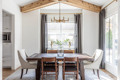 Ispirazione per una sala da pranzo aperta verso la cucina chic di medie dimensioni con pareti bianche e parquet chiaro