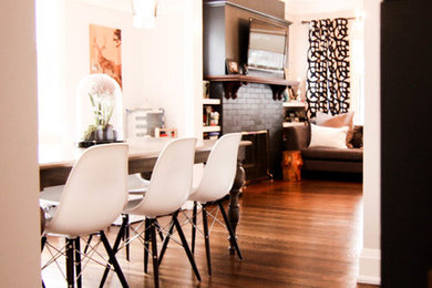 Mittelgroße Moderne Wohnküche mit weißer Wandfarbe, braunem Holzboden, Kamin und Kaminumrandung aus Backstein in Toronto
