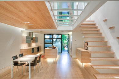 Example of a trendy light wood floor great room design in San Francisco with white walls and no fireplace