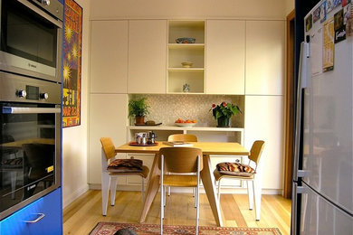 シドニーにある高級な小さなコンテンポラリースタイルのおしゃれなダイニングキッチン (白い壁、淡色無垢フローリング、マルチカラーの床) の写真
