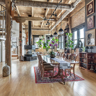 Immagine di una sala da pranzo aperta verso il soggiorno industriale di medie dimensioni con pareti multicolore, pavimento in legno massello medio, pavimento marrone e stufa a legna