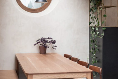 Foto de comedor de cocina minimalista de tamaño medio sin chimenea con paredes beige, suelo de cemento, suelo gris y ladrillo
