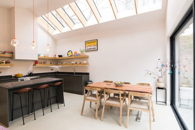 Foto di una sala da pranzo aperta verso la cucina scandinava con pareti bianche e pavimento bianco