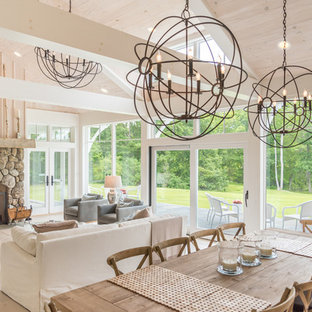 Idee per una grande sala da pranzo aperta verso il soggiorno rustica con pareti beige, parquet chiaro, camino classico, cornice del camino in pietra e pavimento beige