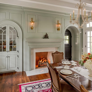 Geschlossenes Klassisches Esszimmer mit grüner Wandfarbe, braunem Holzboden, Kamin und verputzter Kaminumrandung in Philadelphia