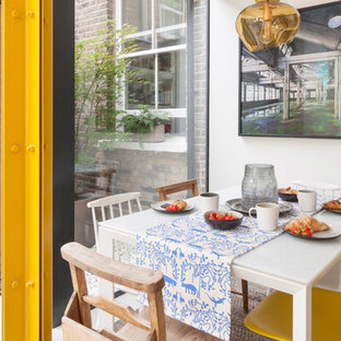 Contemporary dining room in London with white walls and white floors.