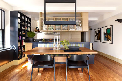 Great room - mid-sized contemporary medium tone wood floor great room idea in New York with white walls