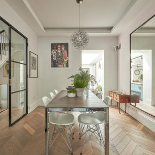 Immagine di una sala da pranzo design di medie dimensioni e chiusa con pareti bianche, pavimento in legno massello medio e pavimento marrone