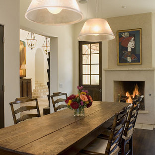 Inspiration for a rustic dark wood floor dining room remodel in Austin with white walls and a standard fireplace