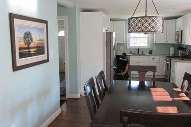 This is an example of a classic dining room in Other with blue walls and dark hardwood flooring.