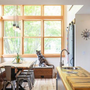 Idee per una piccola sala da pranzo aperta verso la cucina industriale con pareti bianche, parquet chiaro e nessun camino